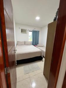 a small room with two beds and a window at Apartamento aconchegante em ilheus in Ilhéus