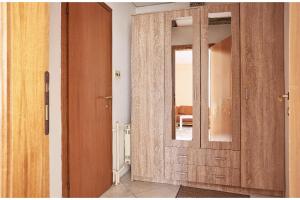 a bathroom with a wooden door and a mirror at Peaceful apartment with yard and parking in Skopje +4 photos