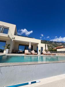 a swimming pool in front of a house at Thalassasense villa lourdata in Kefallonia