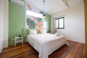 a bedroom with a white bed and a large window at RIVA B&B in Bocas Town