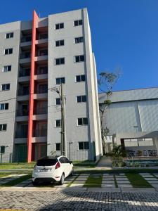 a white car parked in front of a building at Apartamento Bosque Lausanne in Ananindeua