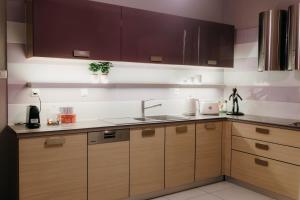 Una cocina con gabinetes de madera y un fregadero. en Apt D5, en Tesalónica 9 fotos más
