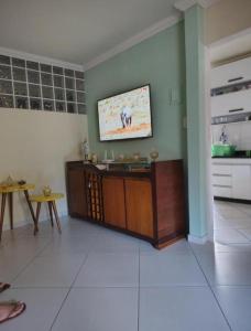 Una sala de estar con un televisor en la pared. en Casa próxima ao expo Minas, en Belo Horizonte