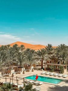 メルズーガにあるRiad Serai Merzougaの砂漠のプールのそばを歩く女性 +24枚の写真