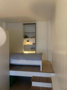 ein kleines Schlafzimmer mit einem Bett und einem Fenster in der Unterkunft Studio appartment in private home at Bjerkaker in Tromsø