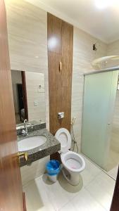 a bathroom with a toilet and a sink at Hotel Lunna in Porto Nacional