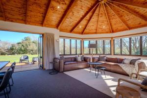 a living room with a couch and a table at Karapiti Lodge - Stunning Rural Getaway in Horohoro