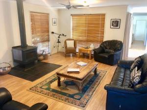 a living room with a couch and a wood stove at 1 Tecoma Ave Stay 3 Pay 2 Winter Special in Sandy Point