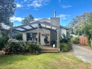 a small house with a deck in the yard at The Vibe Sandy Point Stay 3 Pay 2 Winter Special in Sandy Point
