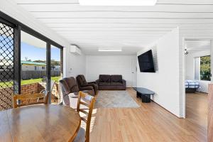 a living room with a table and a couch at Apollo Unit 25 Ground Floor in Narooma
