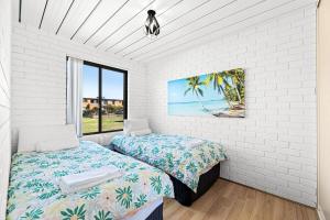 a bedroom with two beds and a window at Apollo Unit 25 Ground Floor in Narooma