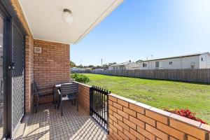a porch with a bench and a brick wall at Apollo Unit 25 Ground Floor in Narooma