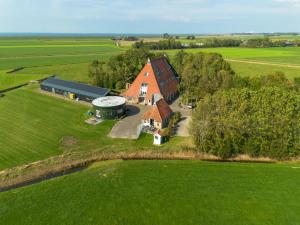 an aerial view of a large house in a field at Het Koetshuis in Pingjum