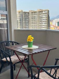 a wooden table with a pot of flowers on a balcony at Turdiu center apart in Tirana +19 photos
