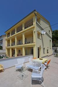 a building with chairs and a table in front of it at Apartments with parking space Dramalj, Crikvenica - 5592 in Dramalj