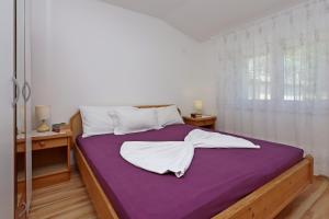 a bedroom with a large bed with a purple blanket at Apartments with parking space Dramalj, Crikvenica - 5592 in Dramalj