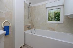 a bathroom with a bath tub and a window at Apartments with parking space Dramalj, Crikvenica - 5592 in Dramalj +45 photos
