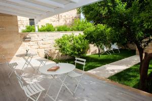 een patio met 2 tafels en stoelen in een tuin bij Bedinle' in Lecce