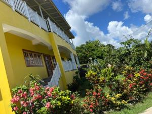 a yellow house with flowers in front of it at Desired View in Choiseul