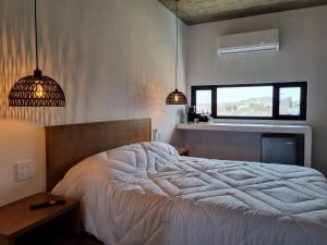 a bedroom with a large bed and two pendant lights at Casa Pacifico, Cerritos Beach in San Carlos
