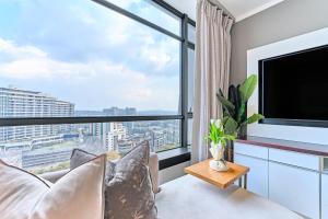 a living room with a tv and a large window at Masingita Towers Hotel, Elegant Sunset Condo in Johannesburg