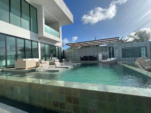 a swimming pool with chairs and a building at Villa Bali in San Andrés