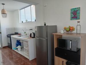 a kitchen with a stainless steel refrigerator and a microwave at Casa Vernaza - Zona residencial - Aeropuerto 5 min in Chiclayo