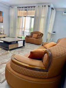 a living room with two chairs and a couch at Abnaa Apartment in Zanzibar City