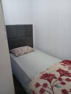 a small bedroom with a bed with a flower blanket at Casa aconchegante in Ouro Preto
