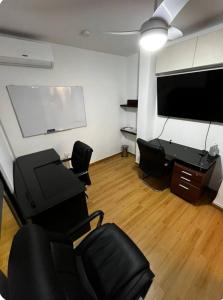 a living room with chairs and a flat screen tv at departamento en ica in Ica