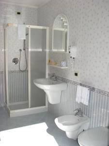 a bathroom with a sink and a toilet and a shower at Hotel Garnì Nès Crépes in Pozza di Fassa