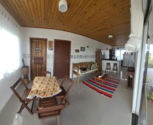 a room with a table and chairs and a kitchen at Casa Peninsula de Maraú in Marau