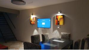 a dining room with a table and a tv on the wall at Departamento PL in Paso de los Libres