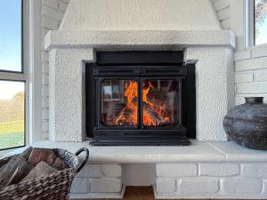 a brick fireplace with a fire in it at 4BR Retreat Near McLaren Vale Wineries Adelaide in Clarendon +43 photos