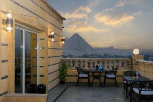 a balcony with a table and a view of the pyramids at Crowne Pyramids View inn in Cairo