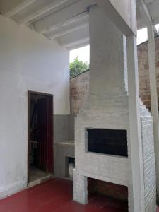 a white brick fireplace in a room with a door at Refúgio na Praia 2 Piscinas in Matinhos