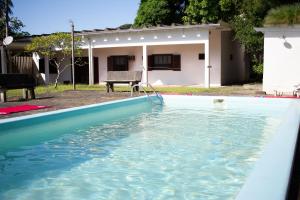 a pool of water in front of a house at Casa Ampla de Praia 2 Piscinas e Ar Condicionado in Matinhos