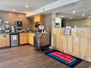 a kitchen with wooden cabinets and a counter with a refrigerator at FairBridge Inn Express Billings Airport in Billings