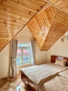 a bedroom with a bed and a wooden ceiling at Kha Phat Central Dalat with Local Charm in Xuan An