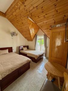 a bedroom with two beds and a wooden ceiling at Kha Phat Central Dalat with Local Charm in Xuan An +32 photos