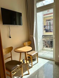 a room with a table and two chairs and a window at Kha Phat Central Dalat with Local Charm in Xuan An