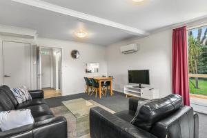 un soggiorno con un divano e una televisione di 2-Bed Townhouse Retreat in Sandy Bay with Parking a Sandy Bay