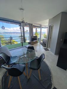 a living room with a glass table and chairs at Casamar paraíso na praia com a vista do mar dos sonhos piscina e spa in Guarujá