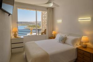 a bedroom with a large bed and a large window at Doñana Beachfront y acceso directo a la playa de Patalavaca in Patalavaca