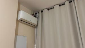 a room with a white curtain and a refrigerator at Apartamento Pé Na Areia, Vista Praia de Copacabana in Rio de Janeiro