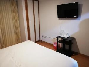 a bedroom with a bed and a flat screen tv at Hotel Sol Internacional in Sogamoso