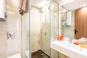 une salle de bain avec une douche en verre et un lavabo dans l'établissement Prestige Apartment in City Center, à Marrakech