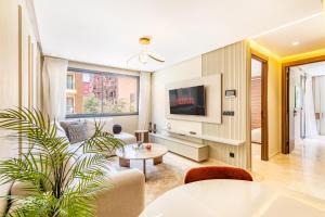 un salon avec un canapé et une télévision dans l'établissement Prestige Apartment in City Center, à Marrakech 4 autres photos