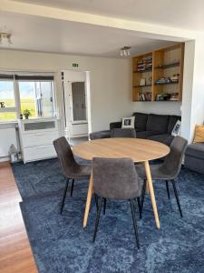 a living room with a wooden table and chairs at Sólvellir Holiday Home in Kjósahreppur