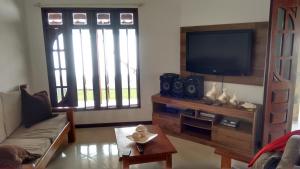 a living room with a couch and a tv at Casa Paraíso dos Lagos in Camacari
